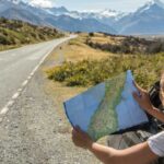 Image of an individual in a car looking down a scenic road.