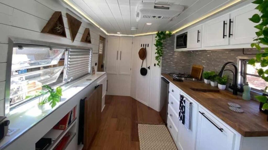 This amazing vintage camper remodel includes paint, shiplap, flooring, countertops, and a beautiful backsplash.