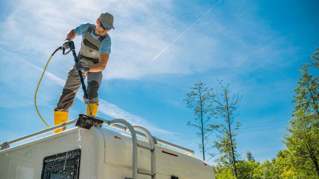 Image of a man washing an RV roof. 