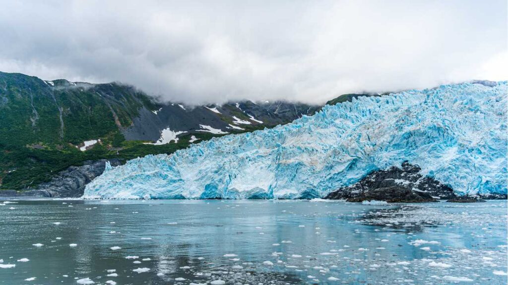 Image of Alyeska Glacier from the water. Foreground has floating chunks of ice. 