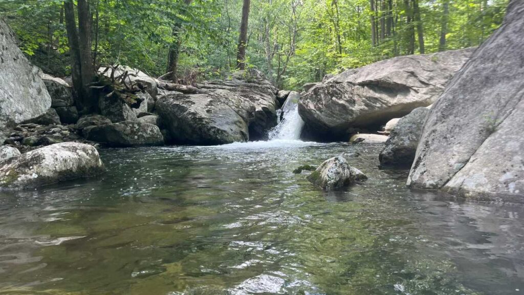 Small waterfall flowing into a natural mountain pool